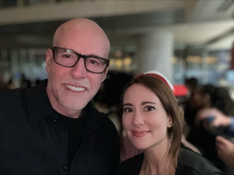 Ania Wysocka posing for a photo with a bald man wearing black-framed glasses at the TED Conference