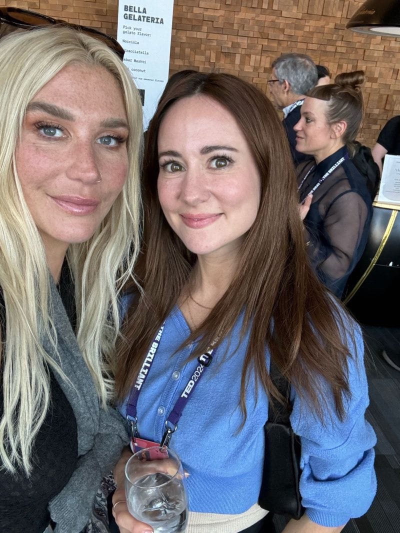 Ania Wysocka and a fellow attendee posing at TED 2024, gelato stand menu visible in the background